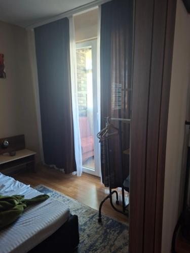 a bedroom with a bed and a door to a patio at Grand Albi Apartament in Gjakove