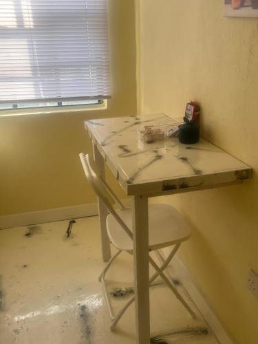 a white desk with a chair in a room at Peaceful in Town in Saint Georgeʼs