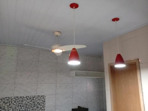 a bathroom with three lights hanging from the ceiling at CASAS e KITNETS NOSSO CANTINHO in Barra do Sahy