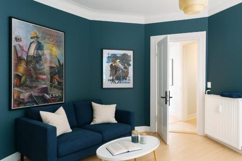 a blue living room with a blue couch and a table at Green Brook - Blue Suite in Aalborg