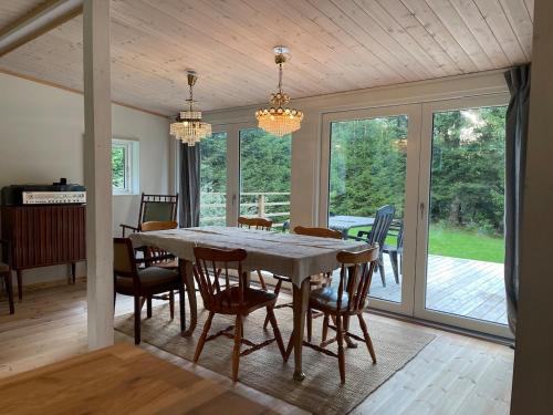 Munka-LjungbyにあるCabin within walking distance of Västersjönのテーブルと椅子と窓のあるダイニングルーム