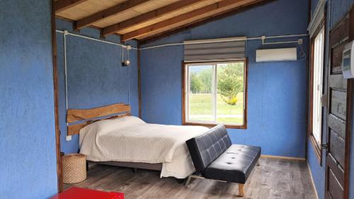 フタレウフにあるTambera Futaleufúのベッドと窓のある寝室