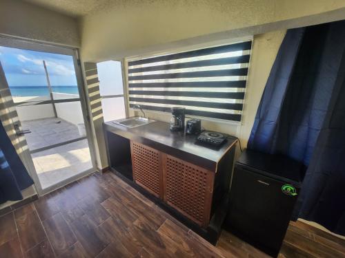a room with a sink and a television and a balcony at MK BEACH Playa Del Carmen in Playa del Carmen