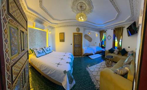 een slaapkamer met een bed en een bank in een kamer bij Riad Dar El bellar in Fès