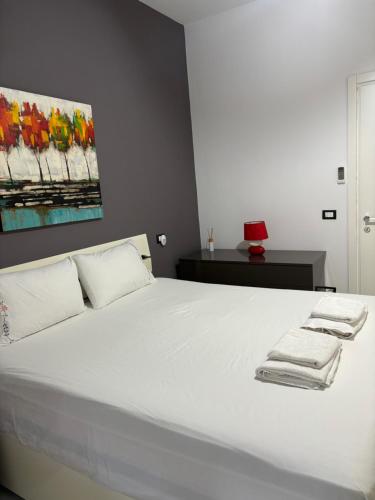 a bedroom with a white bed with towels on it at Green Hill Tirana Apartment in Selitë e Vogël