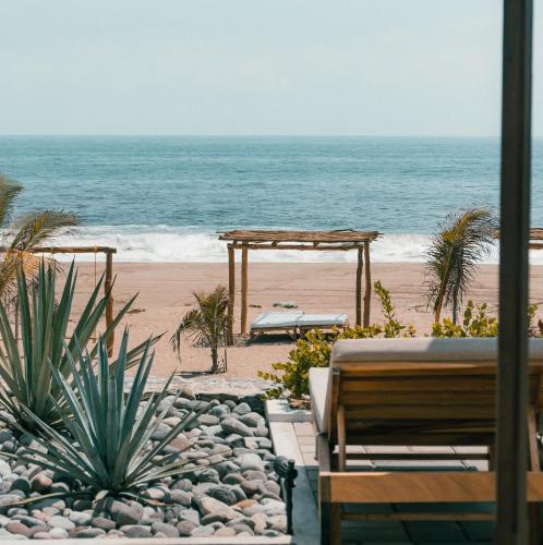 a view of a beach with a pavilion and the ocean at The Garden Suite in El Rebalse