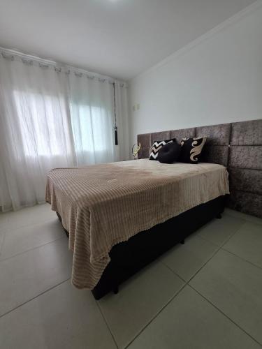 a bedroom with a bed with a blanket on it at Apartamento Artzoo in Pomerode