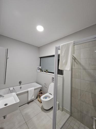 a bathroom with a toilet and a sink and a shower at Costa Bella in Gqeberha