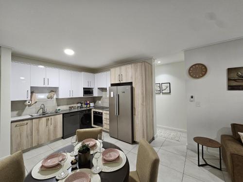 a kitchen with a table and a kitchen with a refrigerator at CostaBella in Gqeberha