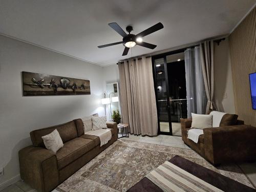 a living room with a couch and a ceiling fan at CostaBella in Gqeberha