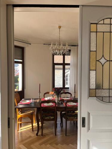 a dining room with a table and chairs and a chandelier at Apparemment de style 70s in Colmar