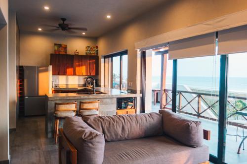 a living room with a couch and a kitchen at The Garden Suite in El Rebalse
