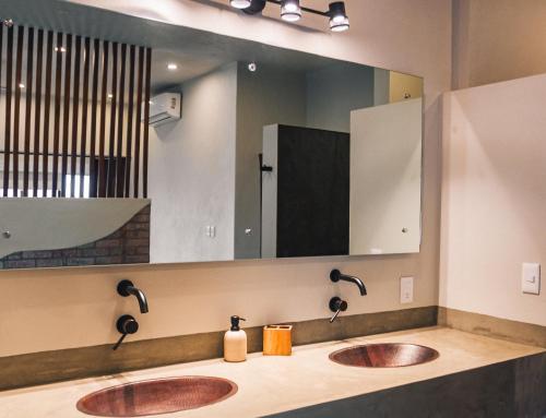 Un baño con dos lavabos y un espejo grande. en The Garden Suite, en El Rebalse