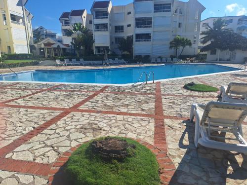 a swimming pool with a stone floor and a resort at ocean view juan dolió in La Puntica de Juan Dolio