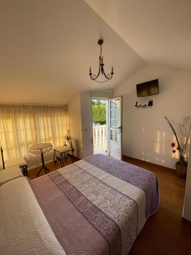 a bedroom with a bed and a sliding glass door at Casa Os Batáns in Vimianzo