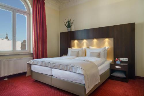 Un dormitorio con una cama grande con una ventana grande. en Garner Hotel Hamburg - Graf Moltke by IHG, en Hamburgo