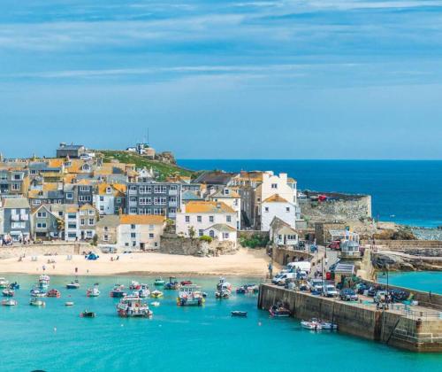 een groep boten in het water bij een strand bij The garden apartment in St Ives