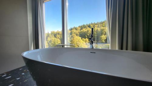 eine Badewanne im Bad mit einem großen Fenster in der Unterkunft Apartament Słoneczny z aneksem Biała Perła Czarna Góra in Heudorf