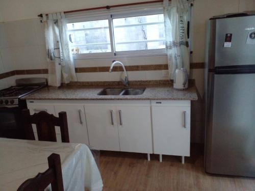 eine Küche mit einer Spüle, einem Kühlschrank und einem Fenster in der Unterkunft Serena del Mar in Nueva Atlantis