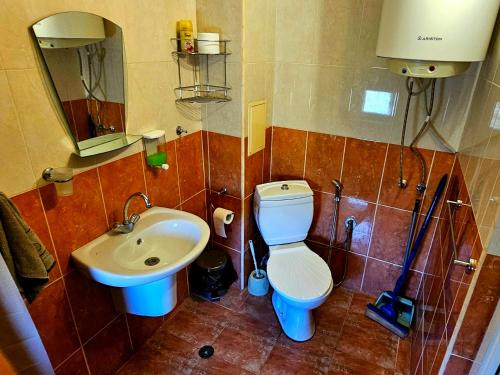 a bathroom with a toilet and a sink at Курортно студио in Sunny Beach