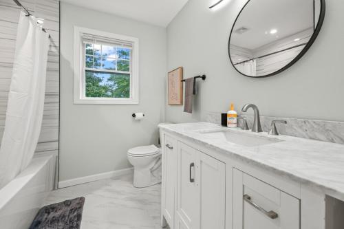 a white bathroom with a sink and a mirror at Ideal Family Stay Sleeps 20 in Bloomfield CT in Bloomfield