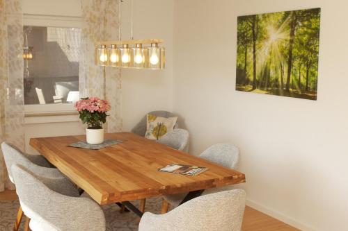 a dining room with a wooden table and chairs at Sonnenterrasse 9 in Fischerbach