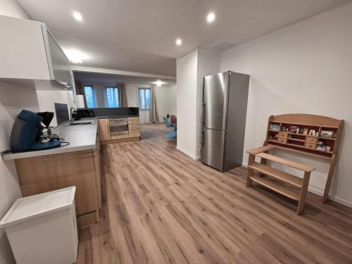 une cuisine avec un réfrigérateur en acier inoxydable et du parquet dans l'établissement Ferienwohnung Krone - nähe Europa-Park, Rulantica, Triberg, à Lahr/Schwarzwald