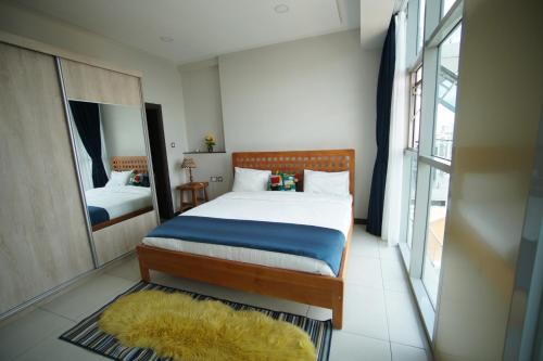 Un dormitorio con una cama grande y un espejo. en Luxury Skynest with Gym and Pool in Westlands, en Nairobi