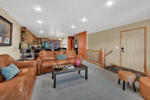 a living room with a couch and a table at Eden Mountain Condo with Views Pool & Hot Tub Access in Wolf Creek Village