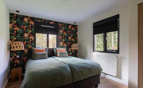 Un dormitorio con una cama con papel pintado floral. en Villa Nami, en Denekamp