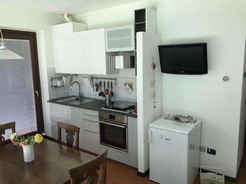 a small kitchen with a table and a refrigerator at Ca' del Maharajà in Gargallo
