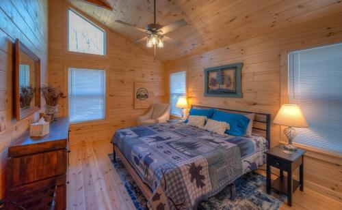 a bedroom with a bed in a log cabin at The Fawn at Deer Ridge in Murphy