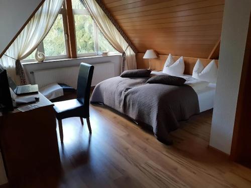 ein Schlafzimmer mit Bett, Schreibtisch und Fenster in der Unterkunft Hotel Haus Niggemann in Hattingen