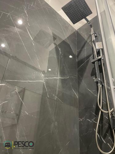 a bathroom with a shower with black marble walls at Pesco Rooms Marineo in Marineo