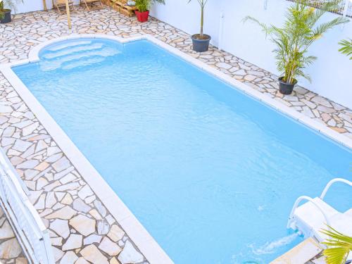 a swimming pool with blue water in a resort at Le Mohana - L'évasion tropicale de l'Est in Saint-André