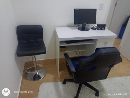 a computer desk with a chair and a computer monitor at Apartamento 88A in São Paulo