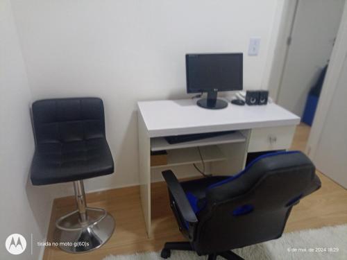 un bureau avec un écran d'ordinateur et une chaise dans l'établissement Apartamento 88A, à São Paulo