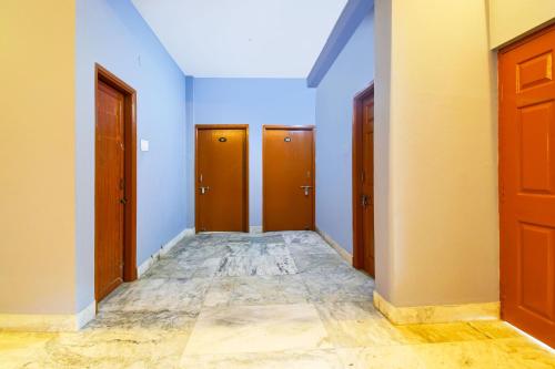KhandagiriHotel O Sawan INN的走廊设有棕色的门,铺有瓷砖地板