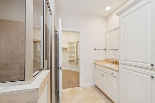 une salle de bain blanche avec un lavabo et un miroir dans l'établissement Highland Park, Oak Lawn Dallas Townhome, à Dallas