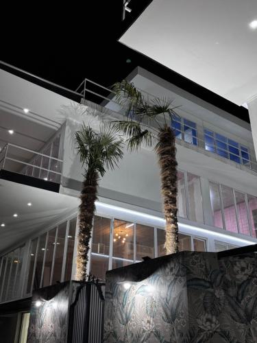 two palm trees in front of a building at Villa Palma in Tbilisi City