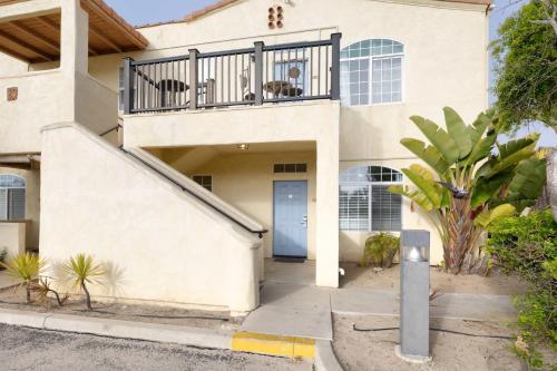 a house with a blue door and a balcony at Sandbar Escape in Oceano