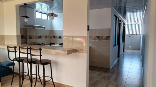 a kitchen with two bar stools and a counter at Amaru 