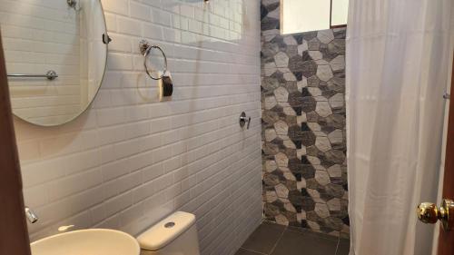 een badkamer met een toilet, een wastafel en een spiegel bij Chakana Wasi in Calca