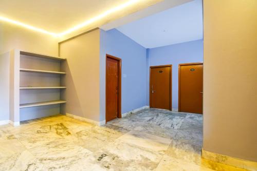 KhandagiriHotel O Sawan INN的一间空房间,设有三扇门,铺有瓷砖地板