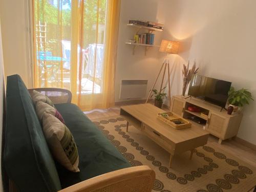a living room with a green couch and a coffee table at Zen and chill F2 appartment and garden near Paris in Chelles