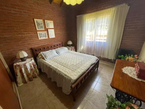 ein Schlafzimmer mit einem Bett und einer Ziegelwand in der Unterkunft Alma del Bosque PILETA E HIDROMASAJES Semiclimatizados in Mar Azul