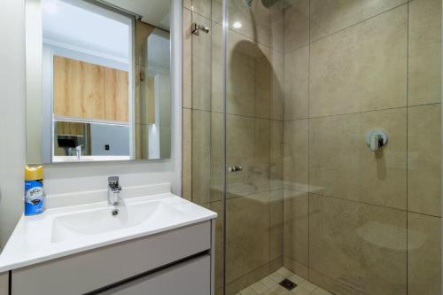 une salle de bain avec lavabo et douche dans l'établissement Ellipse Waterfall 4212, à Midrand