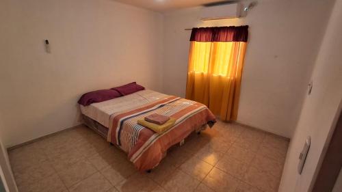 a small bedroom with a bed and a window at Residencial Boveda in Aimogasta