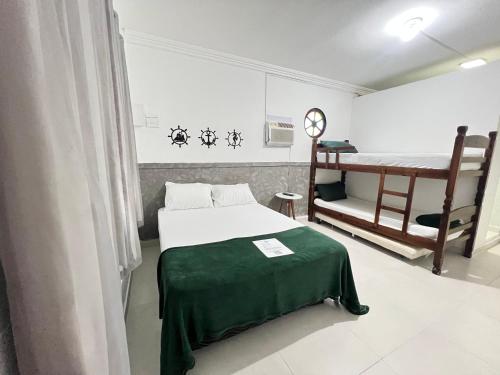 a small room with a bed and a table at Quero mais arraial suites in Arraial do Cabo