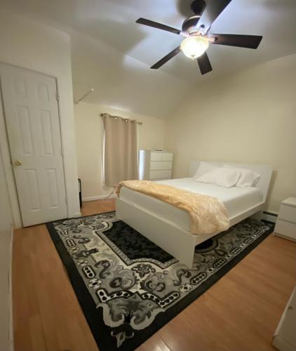a bedroom with a bed with a ceiling fan and a rug at private room in Paterson